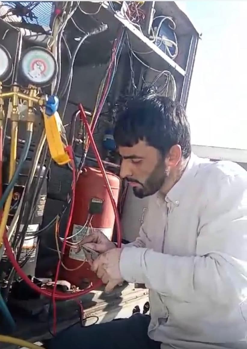 Technician testing an HVAC system with diagnostic equipment